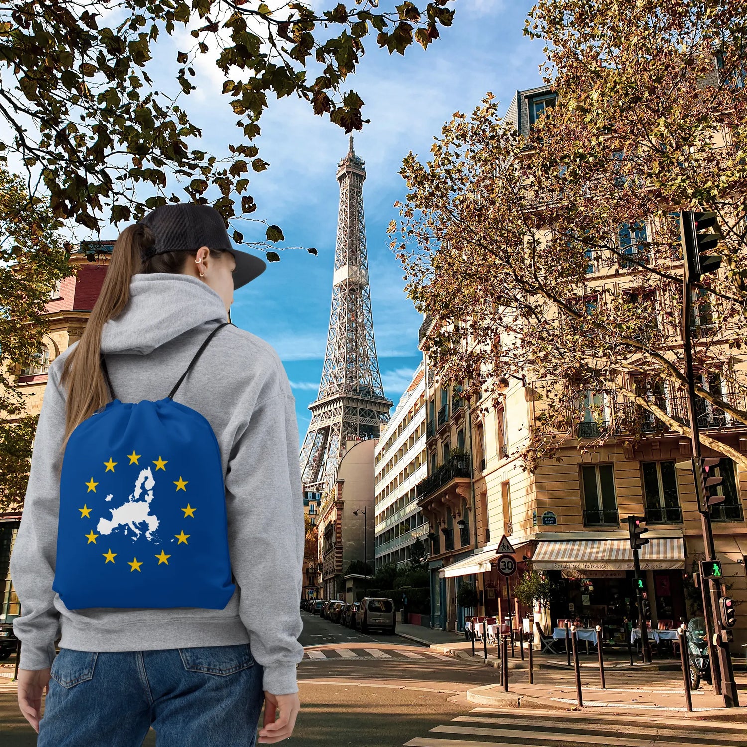 Woman in front of Eiffel Tower with EU themed drawstring bag displaying Europe map